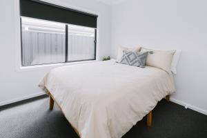 a white bedroom with a large bed and a window at King Bed, 3 Beds, 2 bath, Sleeps 6 in Sale