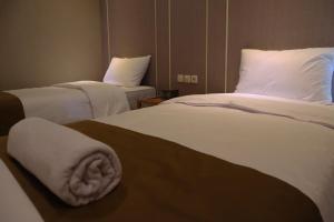 a hotel room with two beds with towels on them at Wakayapa Syariah Residence in Dahung