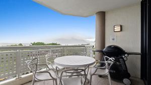 a table and chairs on a balcony with a grill at The Condo at Northshore Tower in Cairns North