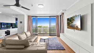 a living room with a couch and a large window at The Condo at Northshore Tower in Cairns North