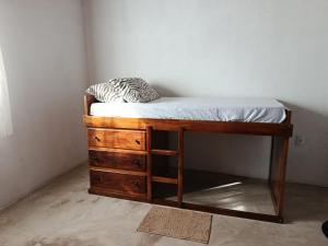 a small bed with a wooden dresser and a mattress at Casa de pedra in Prado