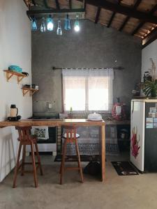a kitchen with a wooden table and two stools at Casa de pedra in Prado