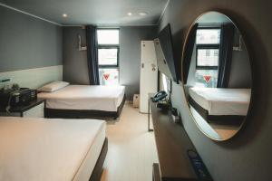 ein kleines Zimmer mit zwei Betten und einem Spiegel in der Unterkunft Hotel Iam in Suncheon + 149 Fotos