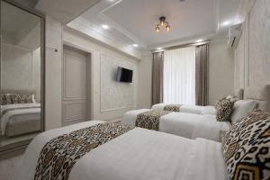 a hotel room with two beds and a television at Mumtoz Hotel in Samarkand
