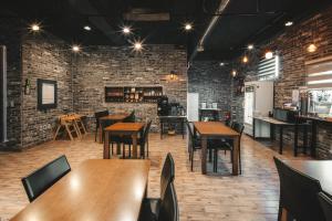 ein Restaurant mit Holztischen und -stühlen und Backsteinwänden in der Unterkunft Hotel Iam in Suncheon