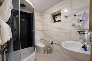 a bathroom with a shower and a sink and a toilet at Mumtoz Hotel in Samarkand