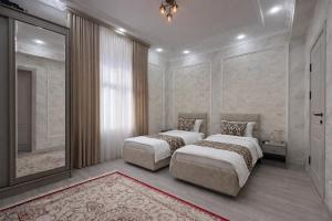 a bedroom with two beds and a large mirror at Mumtoz Hotel in Samarkand