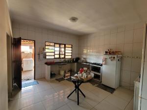 a kitchen with a refrigerator and a table in it at Encanto da Rosa in Cavalcante +5 photos