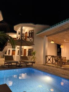 a villa with a swimming pool at night at Jumbo Resort in Paje +23 photos