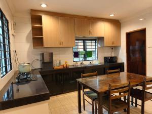 a kitchen with a wooden table and a dining room at Pasadena Home in Tawau