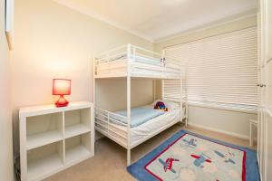 a childs bedroom with bunk beds and a lamp at Sea Forth on Otter in Quindalup