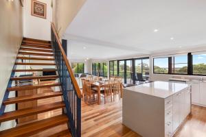 a kitchen and dining room with a staircase in a house at Sea Forth on Otter in Quindalup