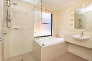 a bathroom with a tub and a sink and a shower at Sea Forth on Otter in Quindalup +21 photos