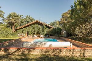 a swimming pool in front of a house at Le cabanon in Mauressac