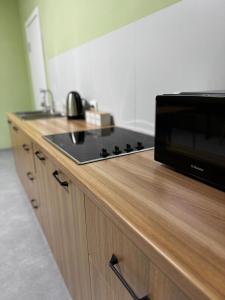 a kitchen counter with a stove and a microwave at HOSTEL Q7 Almaty in Almaty