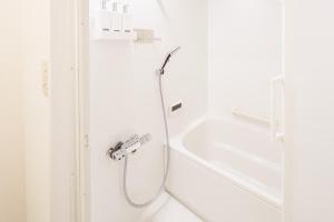 a shower in a white bathroom with a tub at North Nagano Inn in Iiyama +7 photos