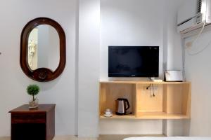 a living room with a tv and a mirror at Island Inn in Boracay