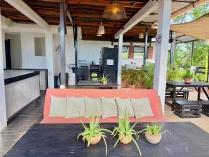a red couch sitting on a patio with plants at Casa OMI in Brisas de Zicatela
