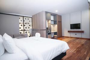 a bedroom with a large white bed and a television at ไดมอนด์ โฮเทล in Ban Krasang