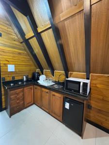 a kitchen with a sink and a microwave on a counter at Refúgio do Morro - Cabana 1 in Torres