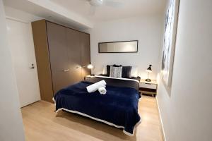 a bedroom with a large bed with two towels on it at Mega Style Apartments Tribeca in Melbourne +8 photos