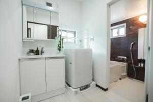 a white bathroom with a shower and a sink at Value Residence Hotel 久貝 in Miyako-jima +23 photos