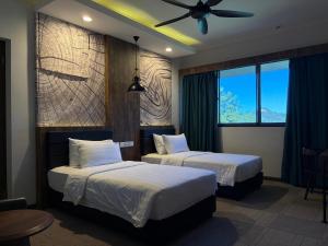 a hotel room with two beds and a ceiling fan at Perkasa Hotel Mt Kinabalu in Kampong Kundassan +44 photos