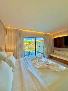 a large white bed in a bedroom with a view at Île Lumière in Pipa