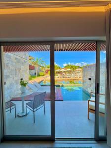 a patio with a table and a view of a pool at Île Lumière in Pipa +18 photos