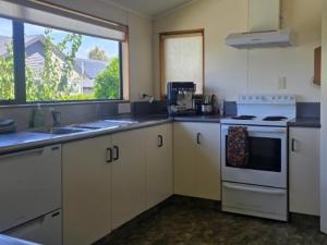a kitchen with a white stove top oven next to a window at Tranquil Tides in Motueka
