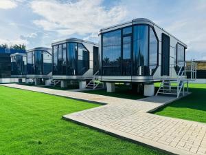 a modern house with glass windows on a grass field at Coolhomtel in Semporna