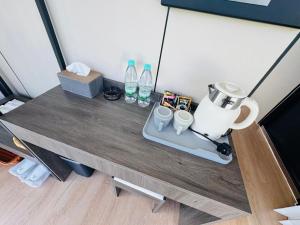 a table with a blender and bottles on it at Coolhomtel in Semporna