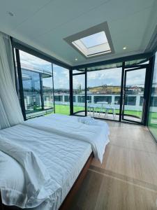 a bedroom with a large bed and large windows at Coolhomtel in Semporna