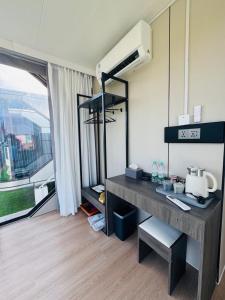 a room with a desk in a room with a window at Coolhomtel in Semporna