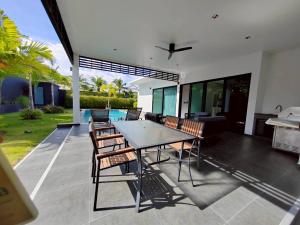 a dining area with a table and chairs on a patio at Sivana HideAway Villas Hua-Hin in Khao Tao