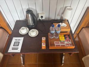 a table with bottles of water and a blender on it at Warsi Bungalow in Ubud