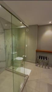 a bathroom with a glass shower and a toilet at Île Lumière in Pipa