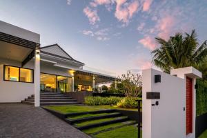 an exterior view of a house with stairs and grass at Sivana HideAway Villas Hua-Hin in Khao Tao