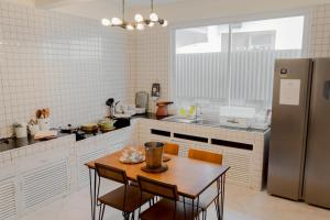 a kitchen with a table and a refrigerator at ชรินพูลวิลล่าบางแสน Aurora Villa Bangsaen natedee road in Chon Buri