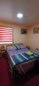 a bedroom with a large bed in a room with a window at Turismo FORTALEZA PATAGONIA in Puerto Natales