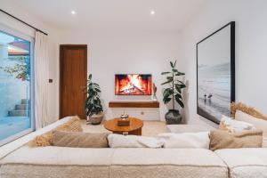 a living room with a couch and a table at Villa Arlo Canggu in Canggu