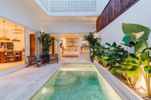 an indoor pool with plants in a house at Villa Arlo Canggu in Canggu