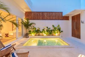 a swimming pool in the middle of a room with plants at Villa Arlo Canggu in Canggu +31 photos