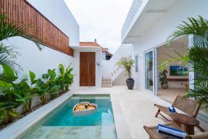 a swimming pool in the middle of a house at Villa Arlo Canggu in Canggu