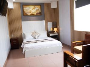 a bedroom with a bed and a painting on the wall at Hoàng Sơn Hotel in Ho Chi Minh City