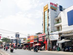 a group of people riding motorcycles down a city street at Hoàng Sơn Hotel in Ho Chi Minh City