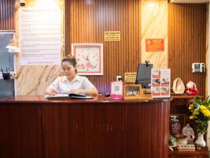 a woman sitting at a counter in a restaurant at Hoàng Sơn Hotel in Ho Chi Minh City