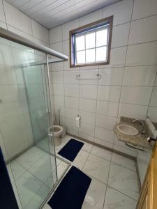 a bathroom with a glass shower and a toilet at Pouso History in Ouro Preto