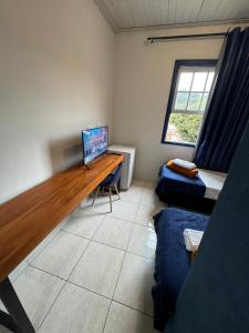 a room with a desk with a computer and a bed at Pouso History in Ouro Preto