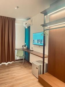 a room with a desk with a monitor and a chair at New Glow Hotel Miri Previously known as Citi Hotel in Miri
